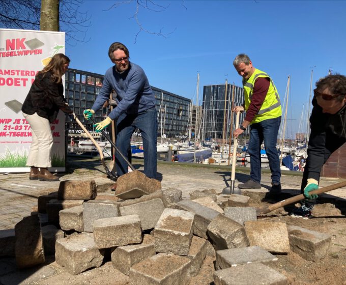 mensen halen tegels uit de grond voor groen tijdens NK tegelwippen Amsterdam Weerproof