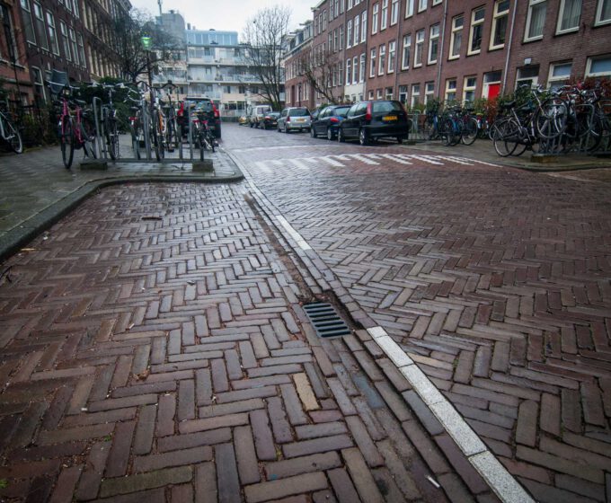 Holle weg bij parkeerplaats stuurt regenwater richting riool Amsterdam Weerproof