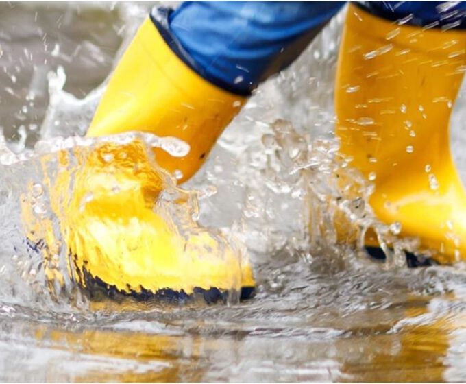 gele laarsjes springen in plas water Amsterdam Weerproof