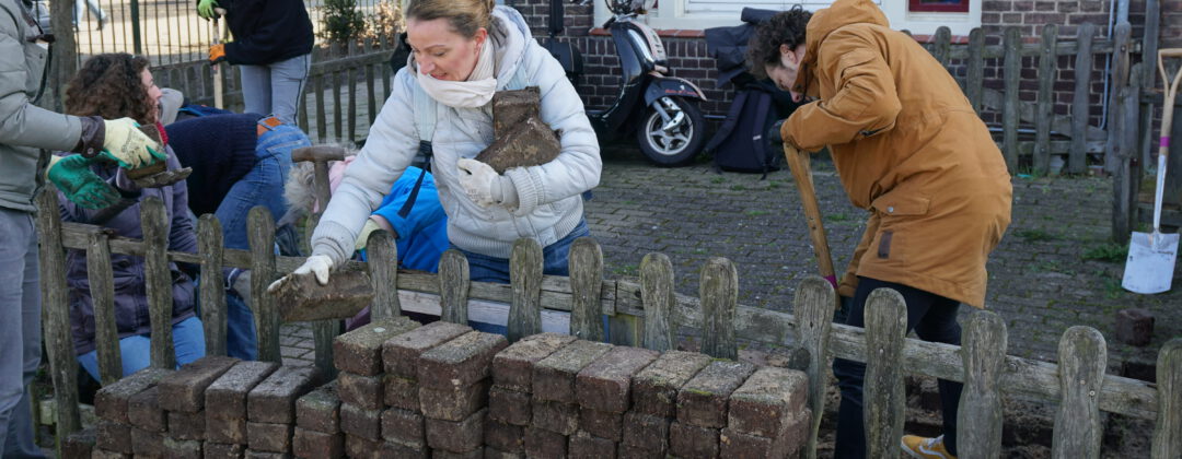 Vrijwilliger werkt aan tuin bij de Heggerankweg Amsterdam Weerproof
