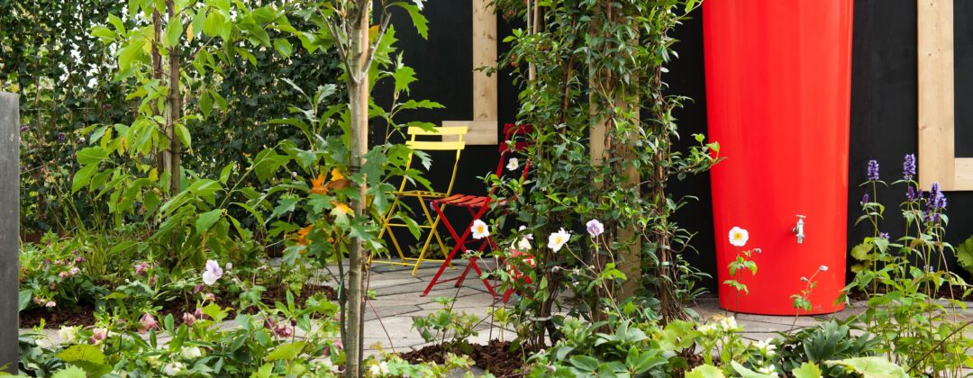 Rode regenton in groene tuin voor regenwateropvang Amsterdam Weerproof