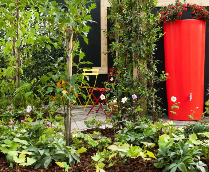 Rode regenton in groene tuin voor regenwateropvang Amsterdam Weerproof