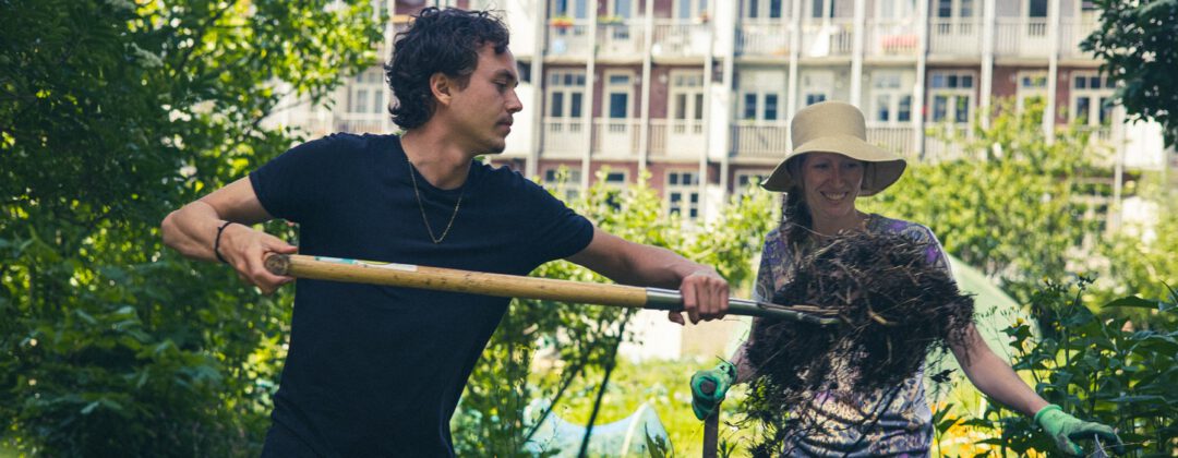 Tuinders aan het werk met hooivork in binnentuin Amsterdam Weerproof