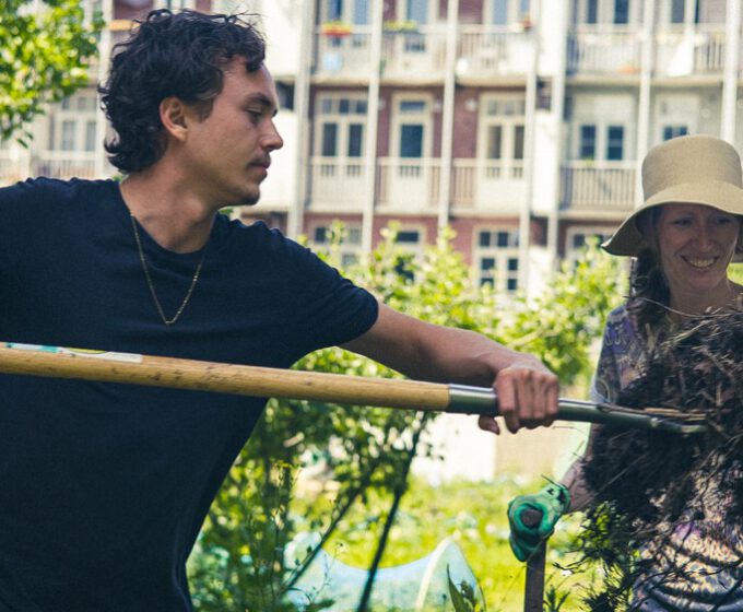 Tuinders aan het werk met hooivork in binnentuin Amsterdam Weerproof