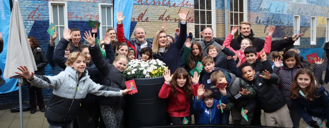 Wethouder met blije kinderen bij opening AnneFrankschool Amsterdam Weerproof