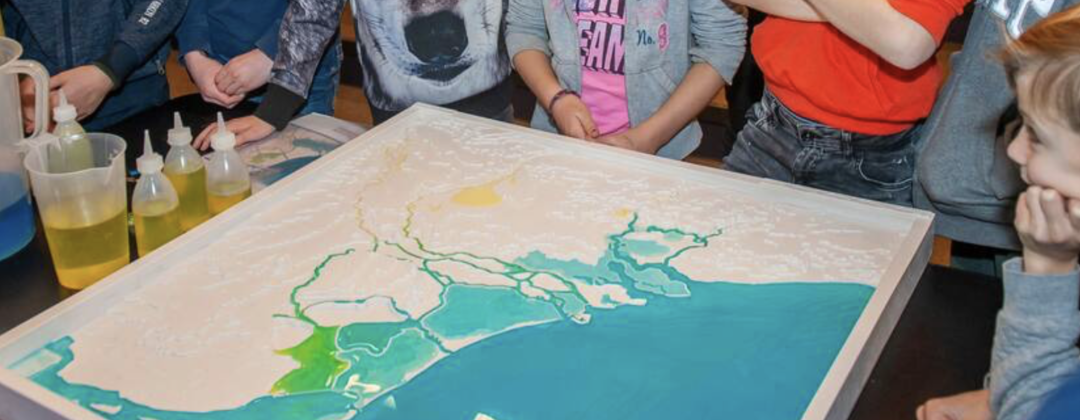 Kinderen kijken naar kaart van Nederlandse delta tijdens Week van Ons Water