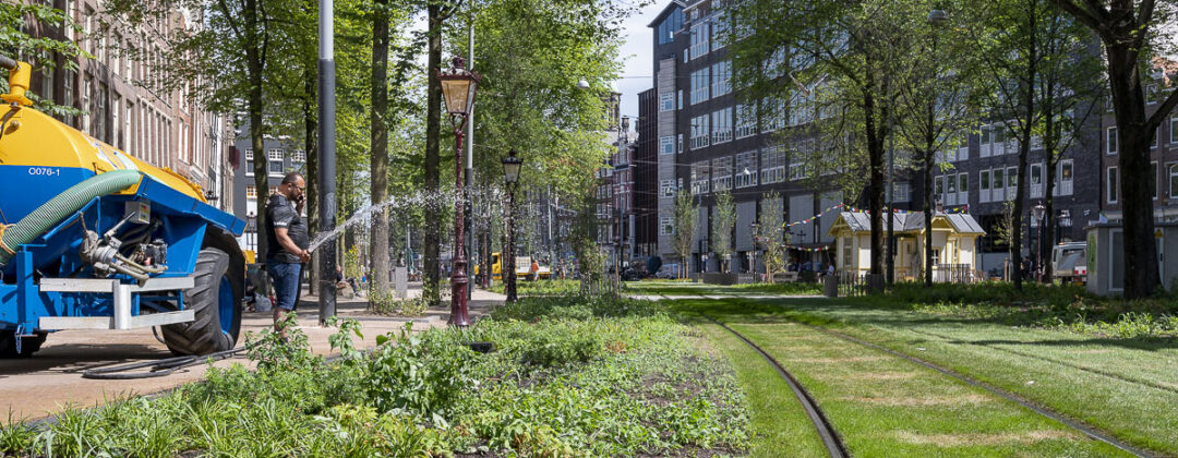groene trambaan wordt besproeid op de Nieuwezijds Voorburgwal Amsterdam Weerproof