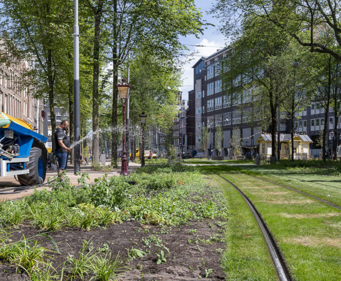 groene trambaan wordt besproeid op de Nieuwezijds Voorburgwal Amsterdam Weerproof