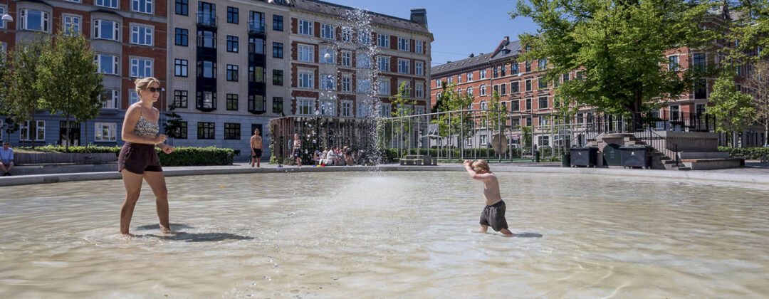 Kind en moeder spelen in water tegen hitte in Oud Zuid Amsterdam Weerproof