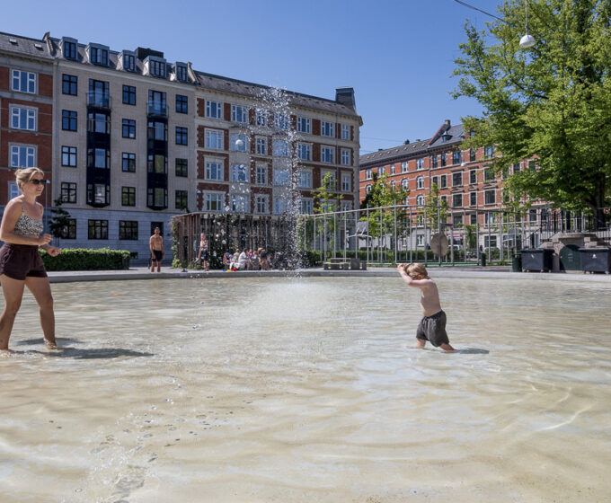 Kind en moeder spelen in water tegen hitte in Oud Zuid Amsterdam Weerproof